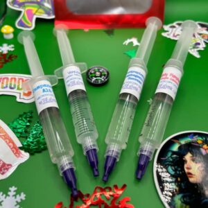 Four syringes, including: Tampanesis Alt, Venezualan, Subtropicalis Hoogshagenii var Convexa, and Hillbilly Pumpkin, along with holiday stickers and trinkets